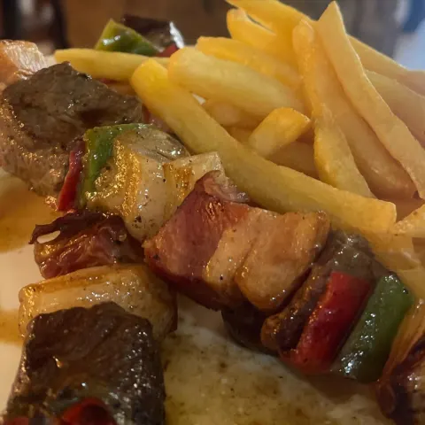 Brochettes a la parrilla con morrón y cebolla, con papas fritas