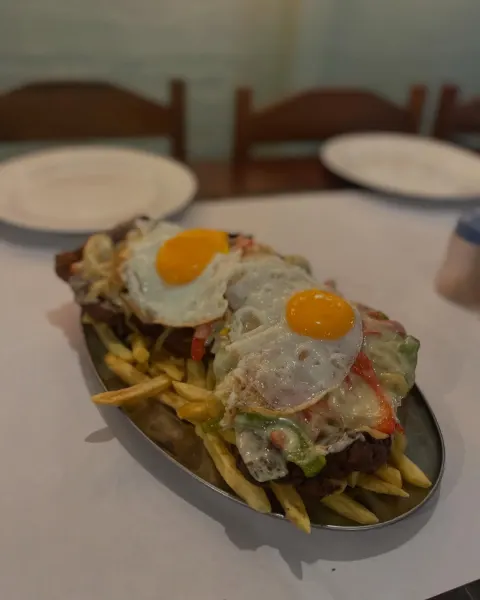 Milanesa a caballo con dos huevos fritos sobre papas fritas