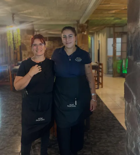 Vero y Dani, las mozas de La Bandera, sonriendo en el salón
